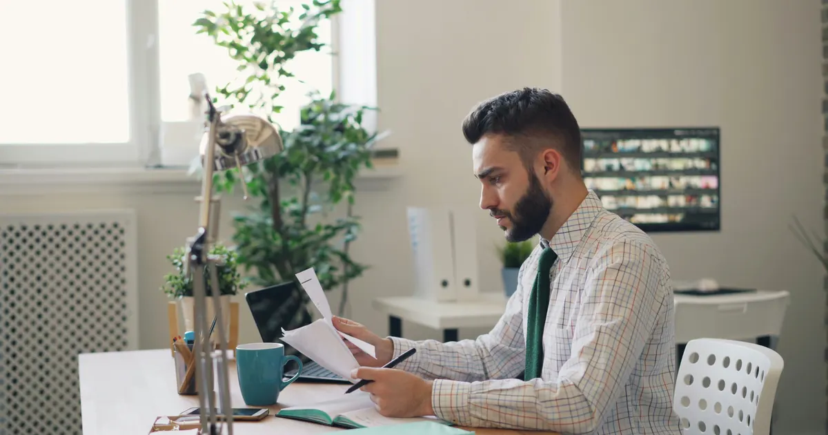 Faut-il changer de mutuelle santé après la hausse des prix en 2026 ? — personne analysant des documents